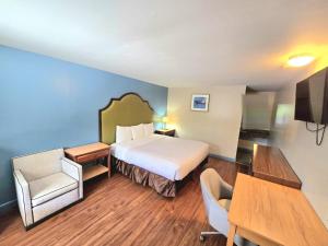 a hotel room with a bed and a table and chairs at Brentwood Inn Richmond South in Beulah Village
