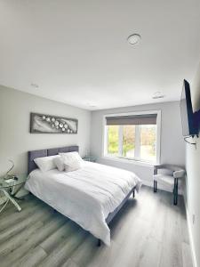 a white bedroom with a large bed and a window at Luxury Nest B&B in Niagara-on-the-Lake