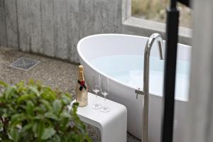 a bottle of champagne sitting on a table next to a bath tub at No.8 Queenstown in Queenstown +42 photos