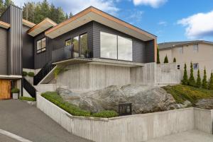 a house with a large rock in front of it at No.8 Queenstown in Queenstown