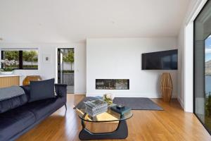 a living room with a black couch and a fireplace at No.8 Queenstown in Queenstown
