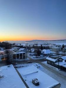 a city covered in snow with the sunset in the background at Modern Downtown Studio - King Bed - Inlet Views in Anchorage