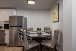 a kitchen with a table with chairs and a refrigerator at Modern Downtown Studio - King Bed - Inlet Views in Anchorage