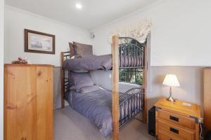 a bedroom with two bunk beds and a window at Private seaside couples hideaway in Kaka Point