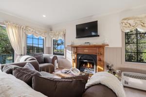 a living room with a couch and a fireplace at Private seaside couples hideaway in Kaka Point
