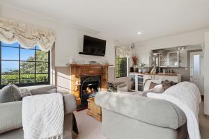 a living room with two couches and a fireplace at Private seaside couples hideaway in Kaka Point