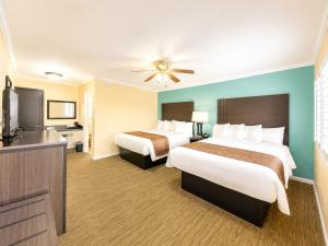 a hotel room with two beds and a flat screen tv at Rockview Inn and Suites - Morro Bay CA in Morro Bay