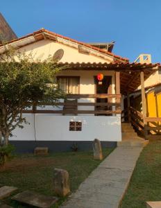 a white house with a pathway in front of it at Casa vicentina in Tiradentes