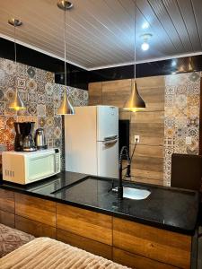 a kitchen with a sink and a white refrigerator at Quarto Aconchegante N 3 in Rio Negro
