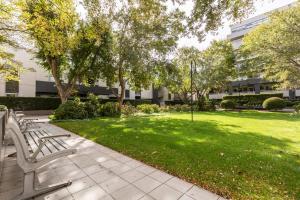 a park with benches and a lawn with trees at The Port Melbourne Experience in Melbourne