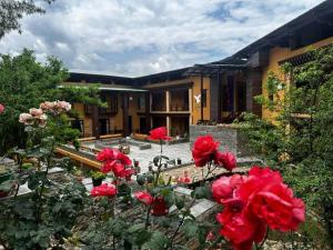 a garden with red flowers in front of a building at Haven Resort Paro in Paro