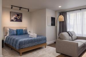 a bedroom with a bed and a couch and a chair at Stylish Downtown Studio - Free Parking plus Kitchen in Anchorage