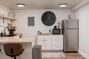 a kitchen with a stainless steel refrigerator and white cabinets at Stylish Downtown Studio - Free Parking plus Kitchen in Anchorage