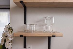 a wooden shelf with glasses on a wall at Stylish Downtown Studio - Free Parking plus Kitchen in Anchorage