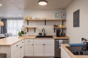 a kitchen with white cabinets and a sink at Stylish Downtown Studio - Free Parking plus Kitchen in Anchorage +13 photos