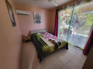 a small bedroom with a bed and a window at KAZ A CE TI MOUN LA, à Deshaies in Deshaies