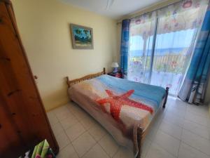 a bedroom with a bed with a red star on it at KAZ A CE TI MOUN LA, à Deshaies in Deshaies