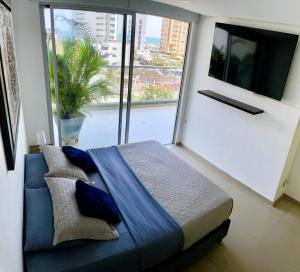a bedroom with a blue bed and a large window at BlueMar Cartagena in Cartagena de Indias