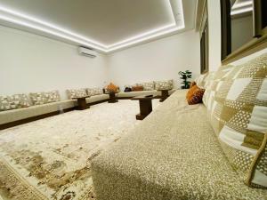 a waiting room with couches and a couch and a rug at Appartement Kais in Laayoune