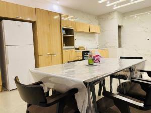 a kitchen with a large white table and chairs at Appartement Kais in Laayoune +12 photos