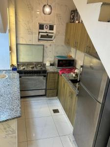 a small kitchen with a stainless steel refrigerator at La mira chalet in Madaba