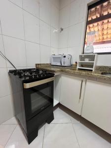 a kitchen with a stove and a counter top at 2 quartos com garagem coberta in Vitória da Conquista +2 photos