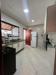 a large kitchen with a refrigerator and a stove at 2 quartos com garagem coberta in Vitória da Conquista