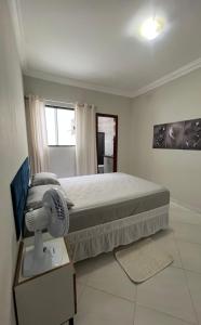 a bedroom with a bed with a fan and a window at 2 quartos com garagem coberta in Vitória da Conquista