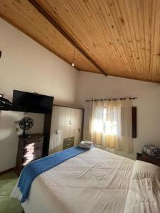 a bedroom with a large bed with a wooden ceiling at Casa vicentina in Tiradentes