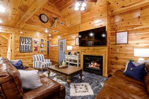 a living room with a couch and a fireplace at Luxury Cabin Near Lake - Sauna, Cold Plunge, Hot Tub, Fire Pit, & Games in Broken Bow +37 photos