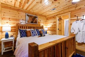 a bedroom with a bed in a log cabin at Luxury Cabin Near Lake - Sauna, Cold Plunge, Hot Tub, Fire Pit, & Games in Broken Bow