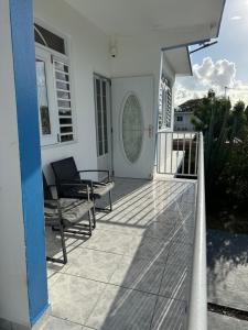a white house with a balcony with a table and a bench at Combate el Carribe Paradise in Cabo Rojo