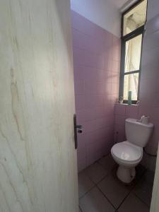 a bathroom with a toilet and a window at Exquisite 1-bed studio apartment in Ikoyi in Lagos