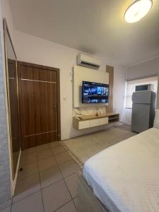 a hotel room with a bed and a flat screen tv at Exquisite 1-bed studio apartment in Ikoyi in Lagos