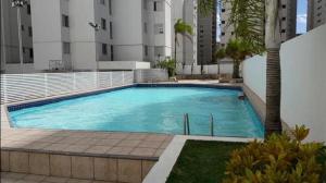 a large swimming pool in front of a building at Apartamento 3 quarto Alto Bueno in Goiânia