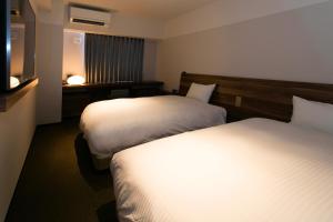 a hotel room with two beds and a television at BRENZA HOTEL in Kobe +34 photos