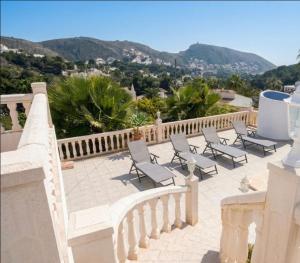a group of chairs sitting on a balcony with mountains at Vista Portet, sleeps 10, Private Pool, Sea Views, Squash, 1 km from El Portet beach in Teulada