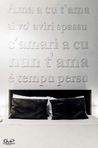 a bedroom with a sign on the wall above a bed at B&B Siracusa in Syracuse