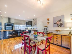 a kitchen with a table and red chairs in it at Cromwell House - Uk42450 in Winforton