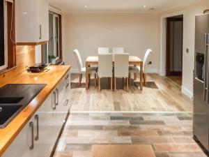 a kitchen and dining room with a table and chairs at Hilbre in Strachur