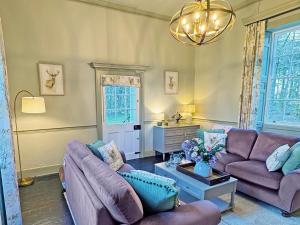 a living room with two couches and a chandelier at Falconer's Lodge in Didlington