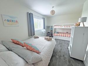a white bedroom with a bed and a crib at Seafields in Sidestrand