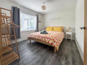 a bedroom with a bed with a colorful bedspread at Seafields in Sidestrand