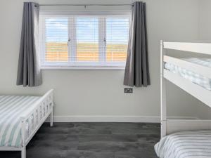 a bedroom with two bunk beds and a window at Seafields in Sidestrand