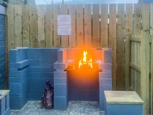 a brick fire pit in front of a wooden fence at Red Kite Cottage-Ukc6982 in Consett +1 photo