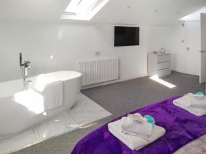 a bathroom with a white tub and a purple rug at Red Kite Cottage-Ukc6982 in Consett