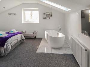 a white bathroom with a tub and a bed at Red Kite Cottage-Ukc6982 in Consett