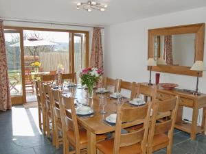 a dining room with a wooden table and chairs at Polmear Barn in Camelford
