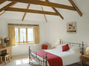 a bedroom with a bed with a red blanket at Polmear Barn in Camelford +9 photos