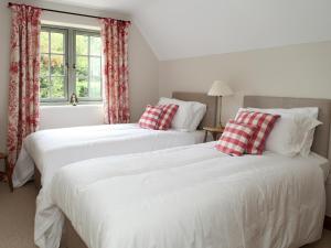 two beds sitting next to each other in a bedroom at Kites Gate Cottage in Kingham